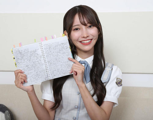選手の魅力や個性、プレー内容がびっしりと書き込まれた「黒見ノート」を手に笑顔を見せる乃木坂46黒見明香（撮影・丹羽敏通）