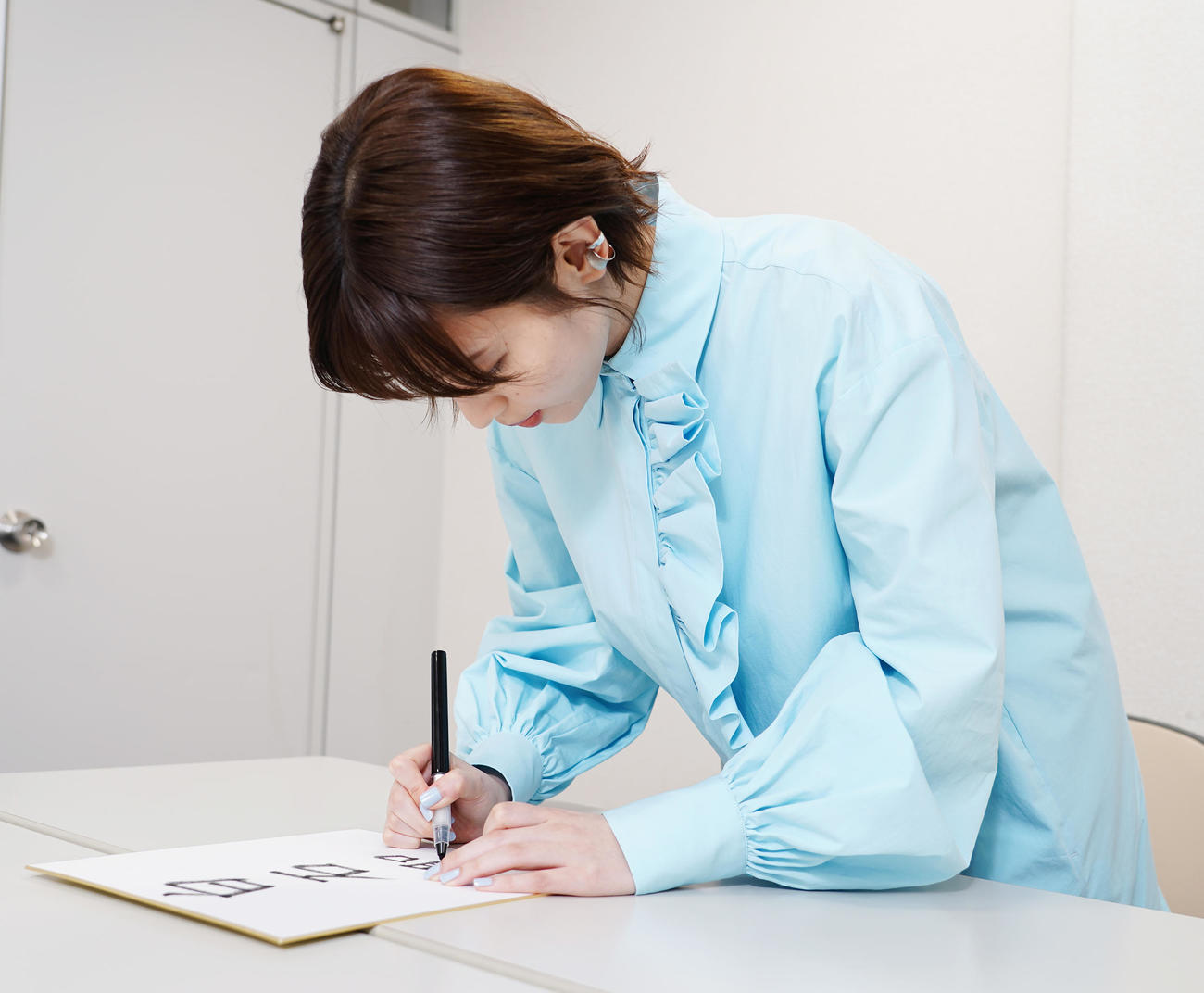 特技の書道で色紙に名前を記す白石聖（撮影・菅敏）