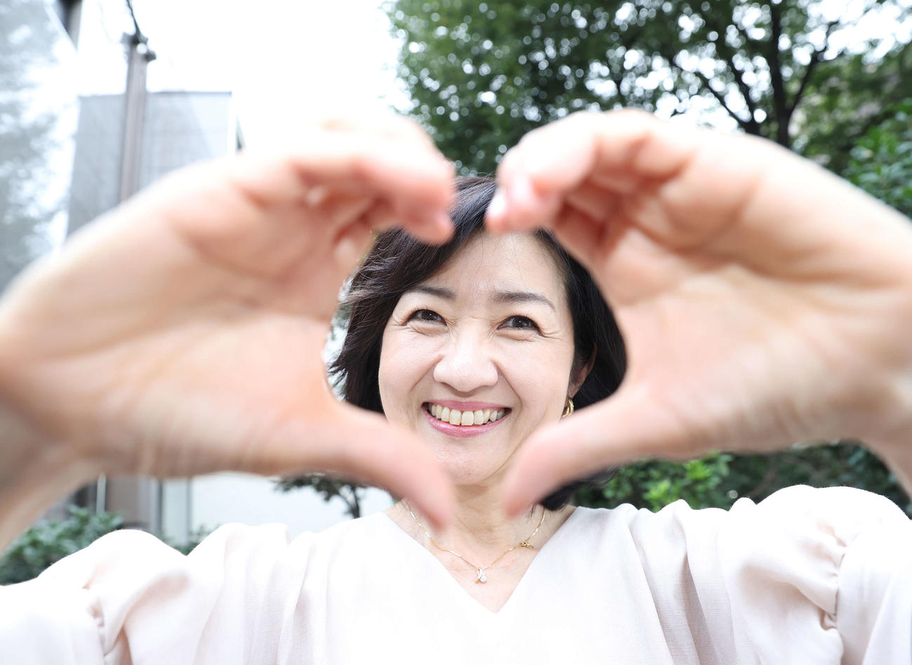 手で作ったハートマークの中から笑顔を見せる寺田理恵子アナウンサー（撮影・河野匠）