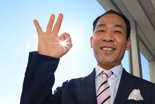 物腰柔らかく気さくな天達武史さん。今日もいい天気とOKポーズのすき間からきらびやかな太陽が顔をのぞかせていた（撮影・垰建太）