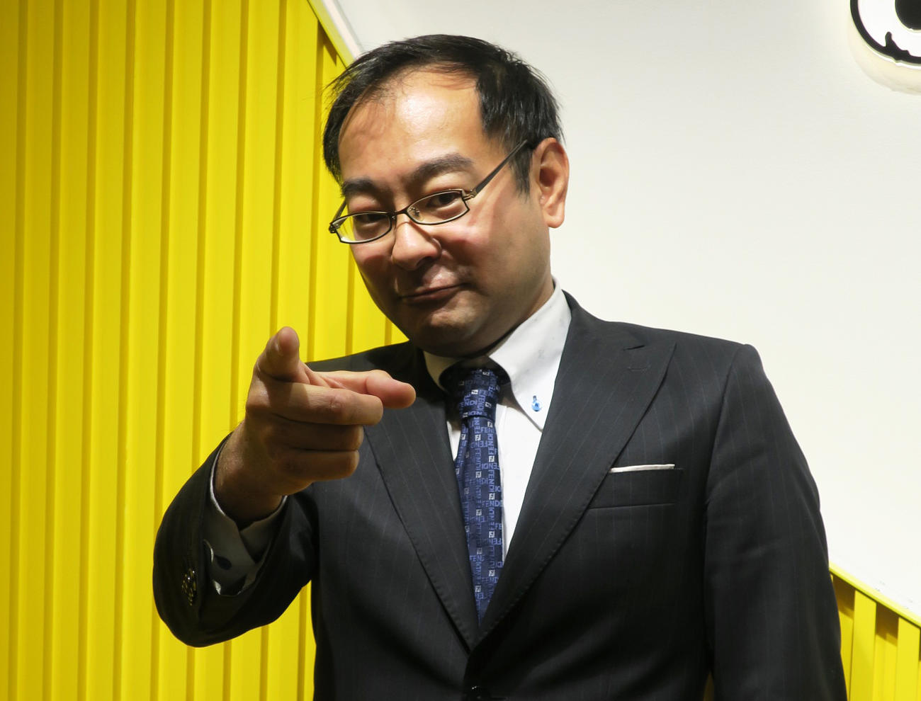 山手線の車内アナウンスを担当し、出発進行のポーズをするニッポン放送飯田浩司アナウンサー