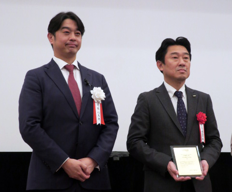 「BRAND OF THE YEAR2022」で。左から、CM総合研究所関根心太郎代表、大賞の表彰を受けるKDDIブランド・コミュニケーション本部長馬場剛史さん