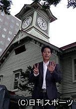 札幌市時計台前でデビュー２５周年を両手で表現する稲垣潤一（撮影・木下淳）