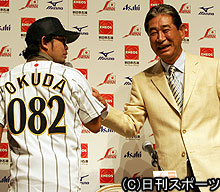 星野監督（右）は奥田民生に広島の市外局番が背番号のユニホームをプレゼント