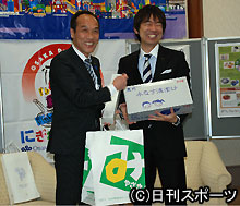 橋下府知事（右）から大阪の特産品をお土産として受け取る東国原県知事