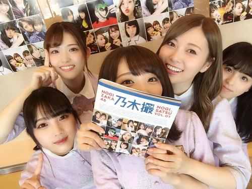 「乃木坂46写真集 乃木撮(のぎさつ) VOL.01」を持って笑顔を見せる乃木坂46メンバーたち。左から与田祐希、松村沙友理、秋元真夏、白石麻衣、大園桃子