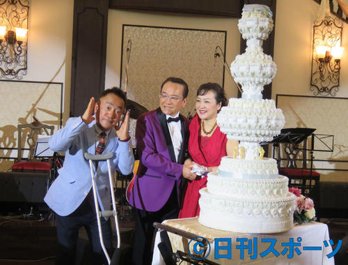 ウエディングケーキ型の誕生ケーキに入刀する湯原昌幸(中）荒木由美子(右）夫妻の横で「ナハナハ」ポーズを決めるせんだみつお