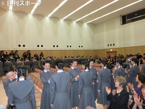 円内周に位置した先輩の本科生から校章を着けてもらう予科生（撮影・村上久美子）