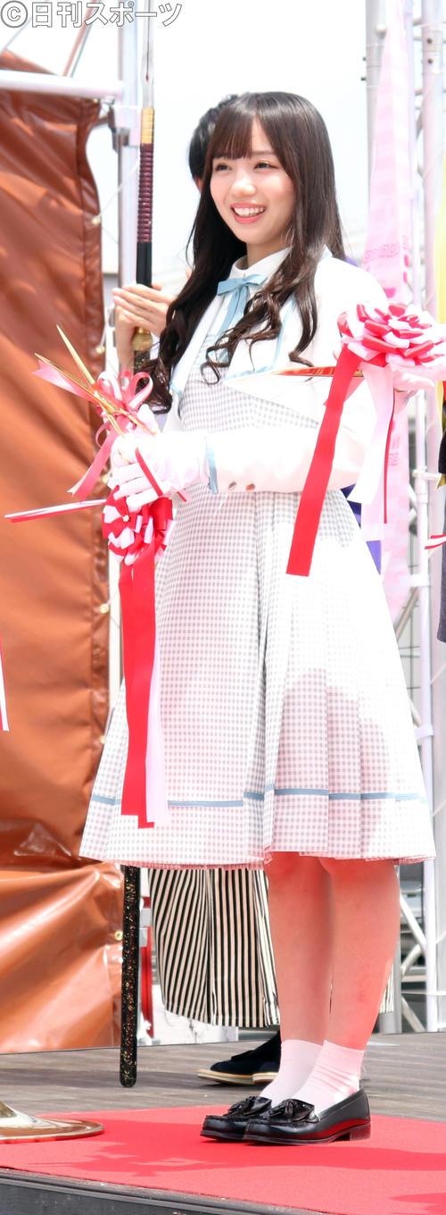 テープカットを行い、笑顔を見せる日向坂46の斉藤京子