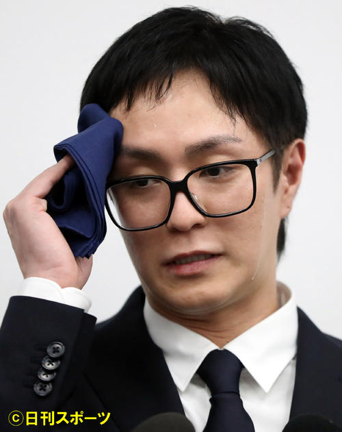21日、エイベックス本社での謝罪会見で汗をぬぐうAAAリーダーの浦田直也