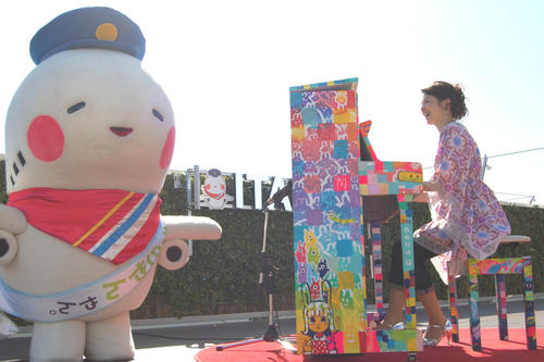 大阪国際空港の展望デッキで「ラブピアノ」を演奏する西村由紀江（右）と隣で踊る関西エアポートグループ公式キャラクター「そらやん」