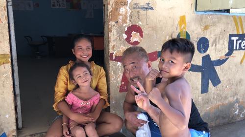 カンボジアで現地の子どもたちと触れ合う角田信朗（右から2人目）