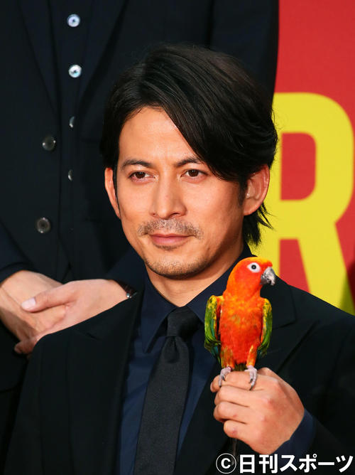 映画「ザ・ファブル」の劇中に登場するインコを手に笑顔を見せる岡田准一（撮影・足立雅史）