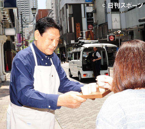 道行く人にアイスコーヒーを配る増位山太志郎（撮影・松本久）