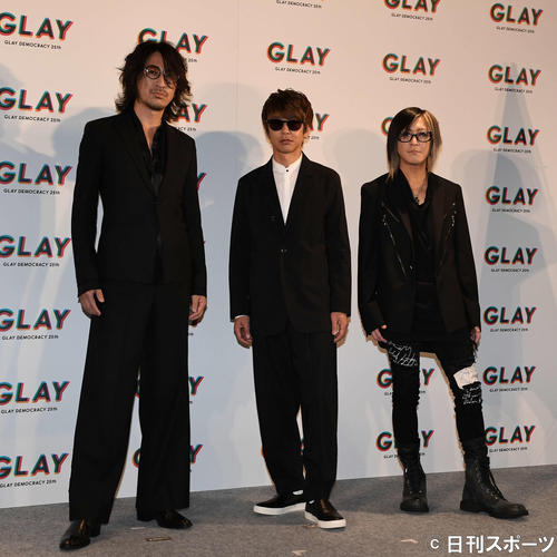デビュー25周年公約発表会のフォトセッションで写真に納まるGLAYの、左からTAKURO、JIRO、HISASHI（撮影・鈴木みどり）