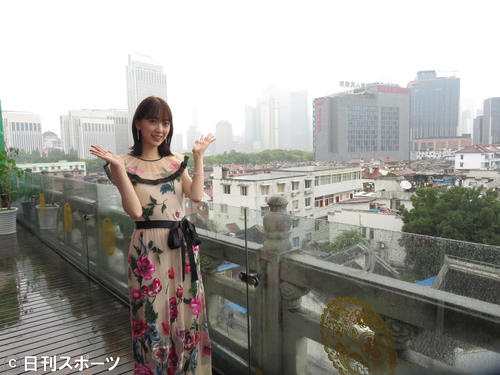 上海の街並みをバックに笑顔を見せる堀未央奈（撮影・横山慧）