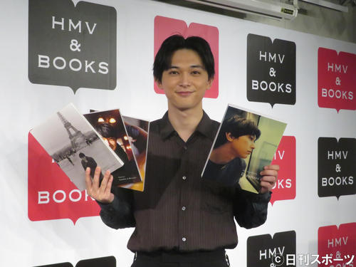 写真集を手にほほ笑む吉沢亮