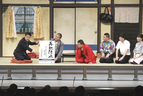 吉本新喜劇の公演に飛び入り出演した山下法相（左端）（共同）