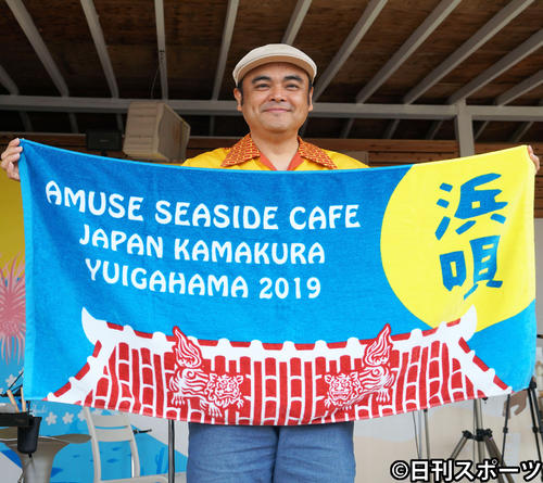 タオルを広げて笑顔のBEGIN比嘉栄昇（撮影・遠藤尚子）