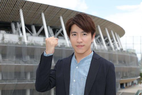 建設中の新国立競技場をバックにガッツポーズを見せる、フジテレビの東京五輪メインキャスターの関ジャニ∞村上信五（C）フジテレビ