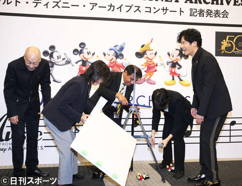 フォトセッション時にセッティングしたミッキーのぬいぐるみを、またもスタッフが崩してしまい思わず爆笑してしまう稲垣吾郎（右）と音楽監督の島健（左）（撮影・河田真司）