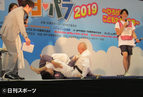 「兵庫県オールトヨタスポーツフェスティバル」で、パラ柔道の広瀬誠氏（中央右）と対戦するサバンナ八木（中央左）。左はMCの陣内智則（撮影・星名希実）