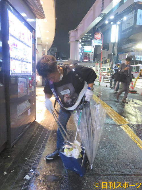 雨の降る中、渋谷ハチ公前広場でゴミを拾うカラテカ入江慎也