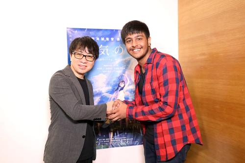 署名活動を始めた男子高校生と握手する新海誠監督（左）