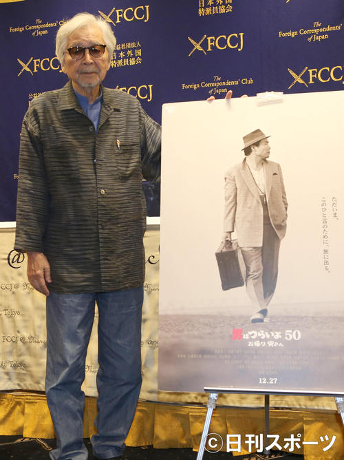 会見後ポスターの横に立つ山田洋次監督（撮影・佐藤成）