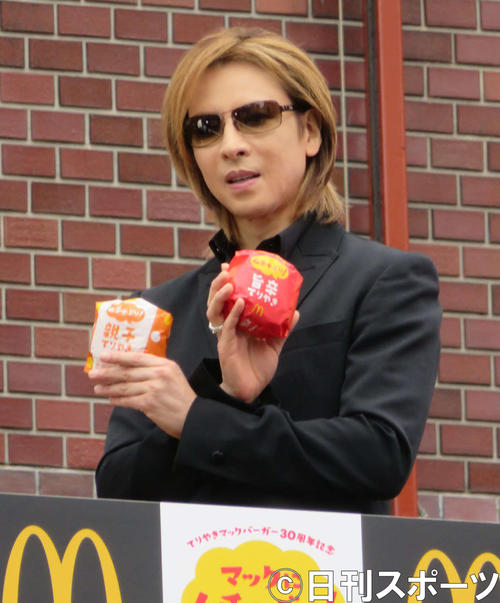 自ら考案した親子てりやきマックバーガー(左)と旨辛てりやきバーガーを手にするYOSHIKI