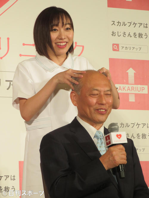 舛添要一氏（右）に頭皮マッサージを行う須田亜香里