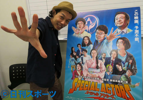 「スペシャルアクターズ」のポスターを前に、笑顔でポーズする上田慎一郎監督（撮影・村上幸将）