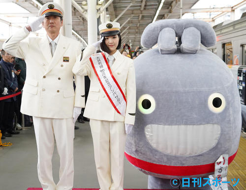大井町線90周年記念列車出発式で一日駅長に就任した12人組女性アイドルグループ、BEYOOOOONDSの一岡伶奈（中）。左は栗山駅長。右は東急線キャラクターのるるん（撮影・佐藤成）