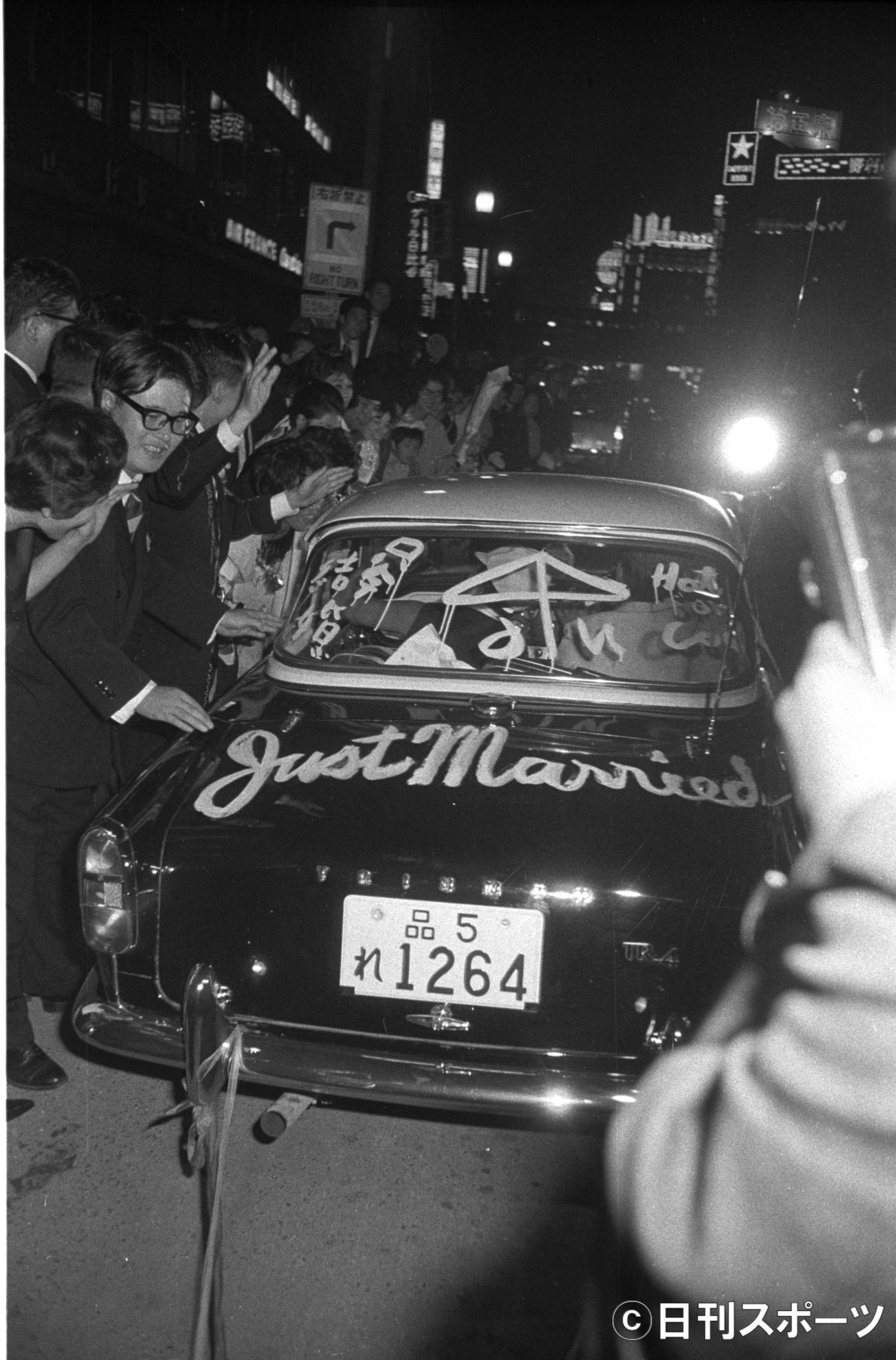 「JUST　MARRIED」と車に書いて結婚式場を後に。アクションスターらしい粋なパフォーマンス＝1962年10月