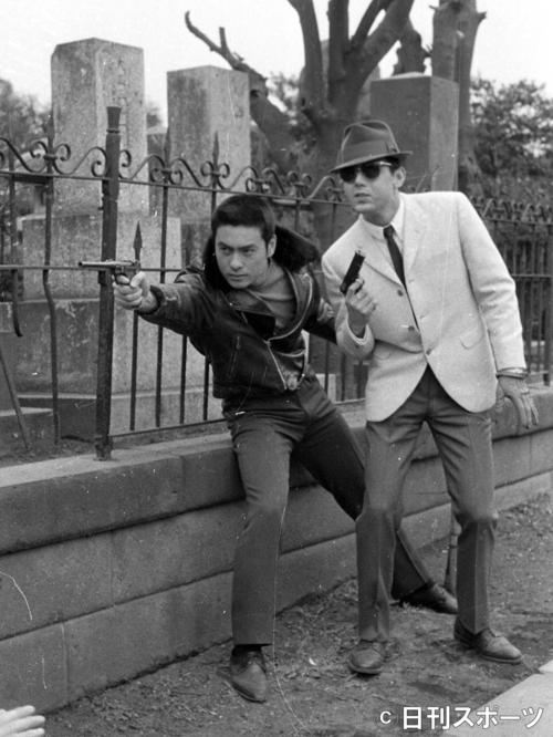 撮影で高橋英樹（左）と銃を構える＝64年