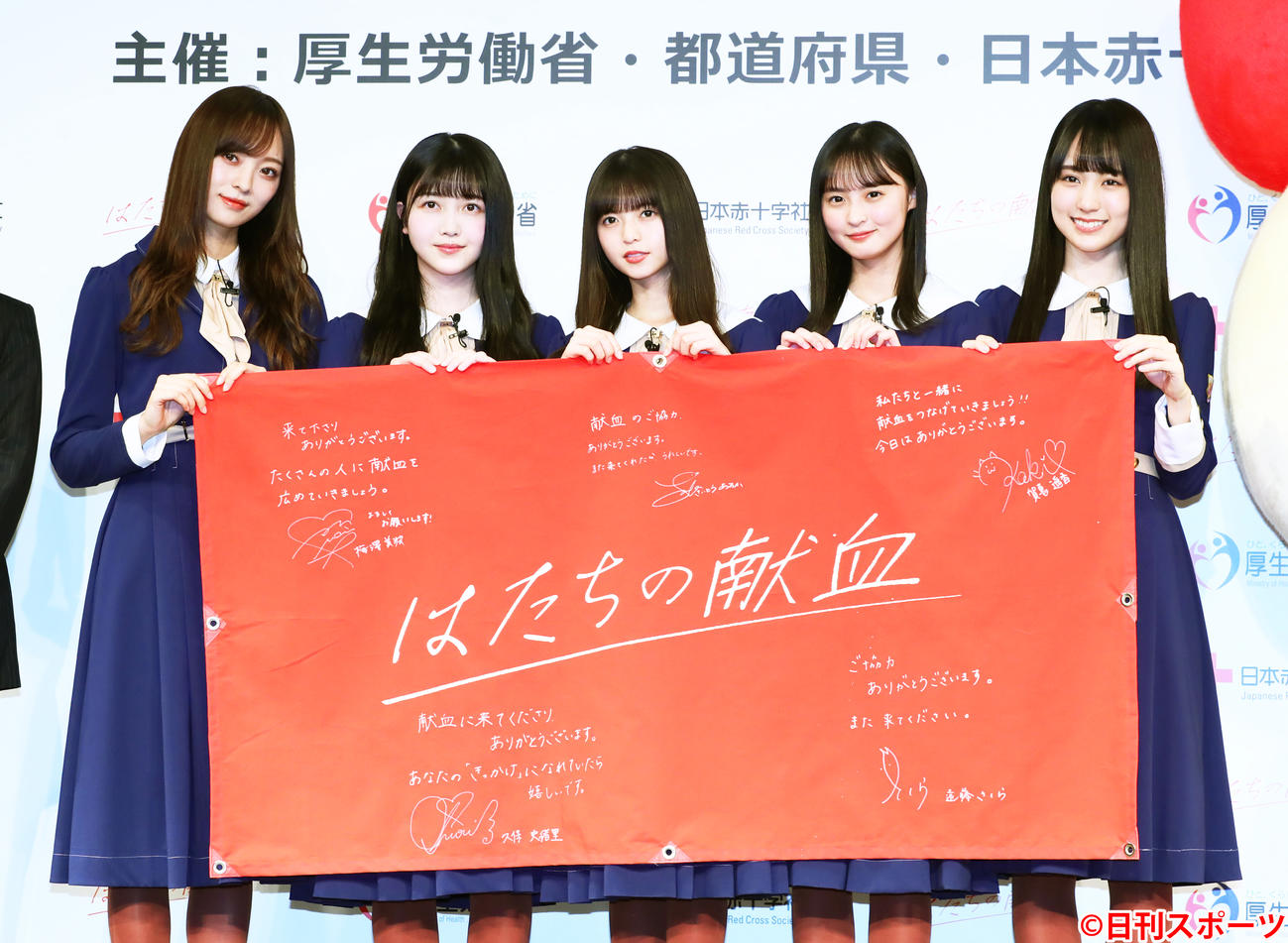 フラッグにメッセージを入れ献血をPRする乃木坂46の、左から梅澤美波、久保史緒里、斎藤飛鳥、遠藤さくら、賀喜遥香（撮影・足立雅史）