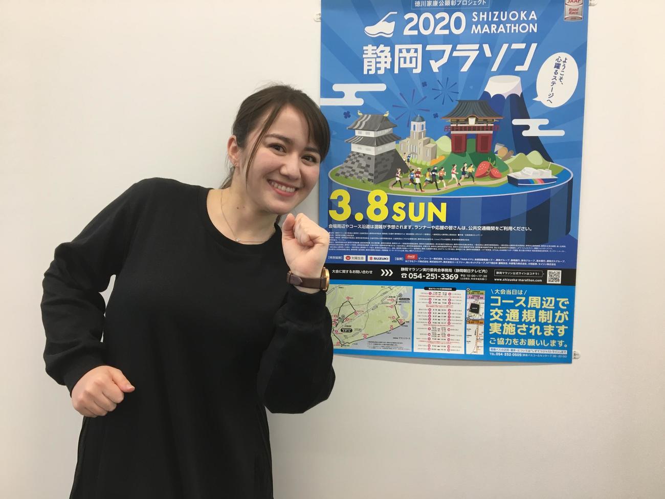 静岡朝日テレビのスミス春子アナウンサーは、静岡マラソンのPRポスターの前でランニングポーズを披露