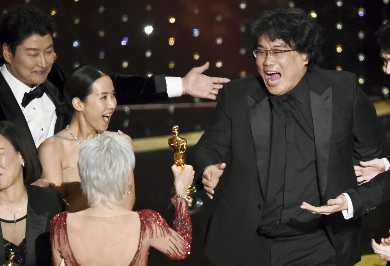 第92回米アカデミー賞で作品賞を受賞し、喜ぶ「パラサイト」のポン・ジュノ監督（右）と出演者ら（AP＝共同）