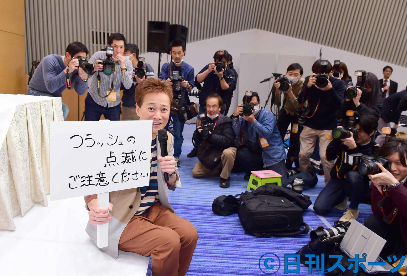 会見前に会場に乱入し「フラッシュの点滅にご注意ください」と書かれたボードを手にカメラマンにアピールする中居正広（撮影・小沢裕）