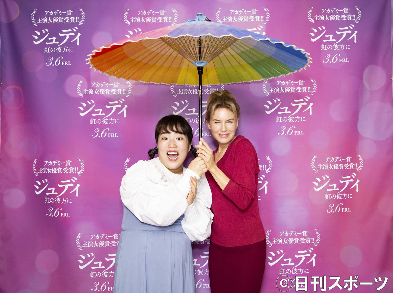 虹色の和傘で相合い傘をする、ゆりやんレトリィバァ（左）とレネー・ゼルウィガー