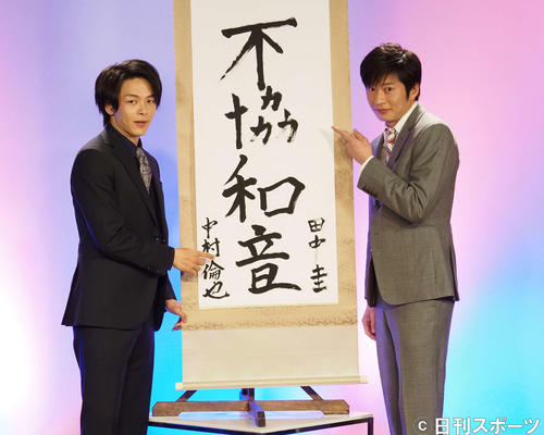 田中圭(左)が「不協」、中村倫也が「和音」を書いた掛け軸の前で記念撮影(撮影・遠藤尚子)