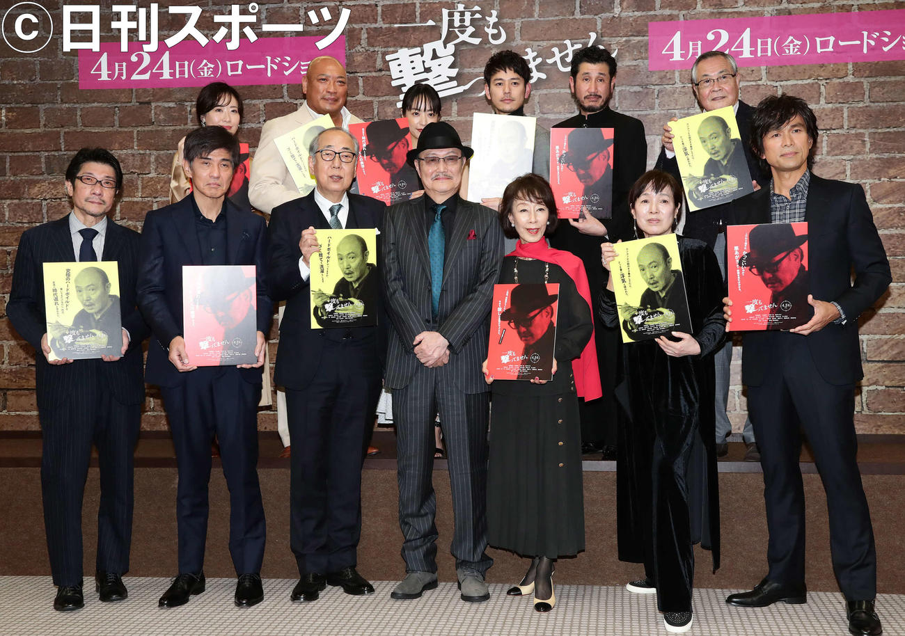 完成報告会で主演の石橋蓮司のパネルを手に写真に納まる、前列左から阪本順治監督、佐藤浩市、岸部一徳、石橋蓮司、大楠道代、桃井かおり、江口洋介。後列左から前田亜季、新崎人生、井上真央、妻夫木聡、渋川清彦、小野武彦（撮影・丹羽敏通）