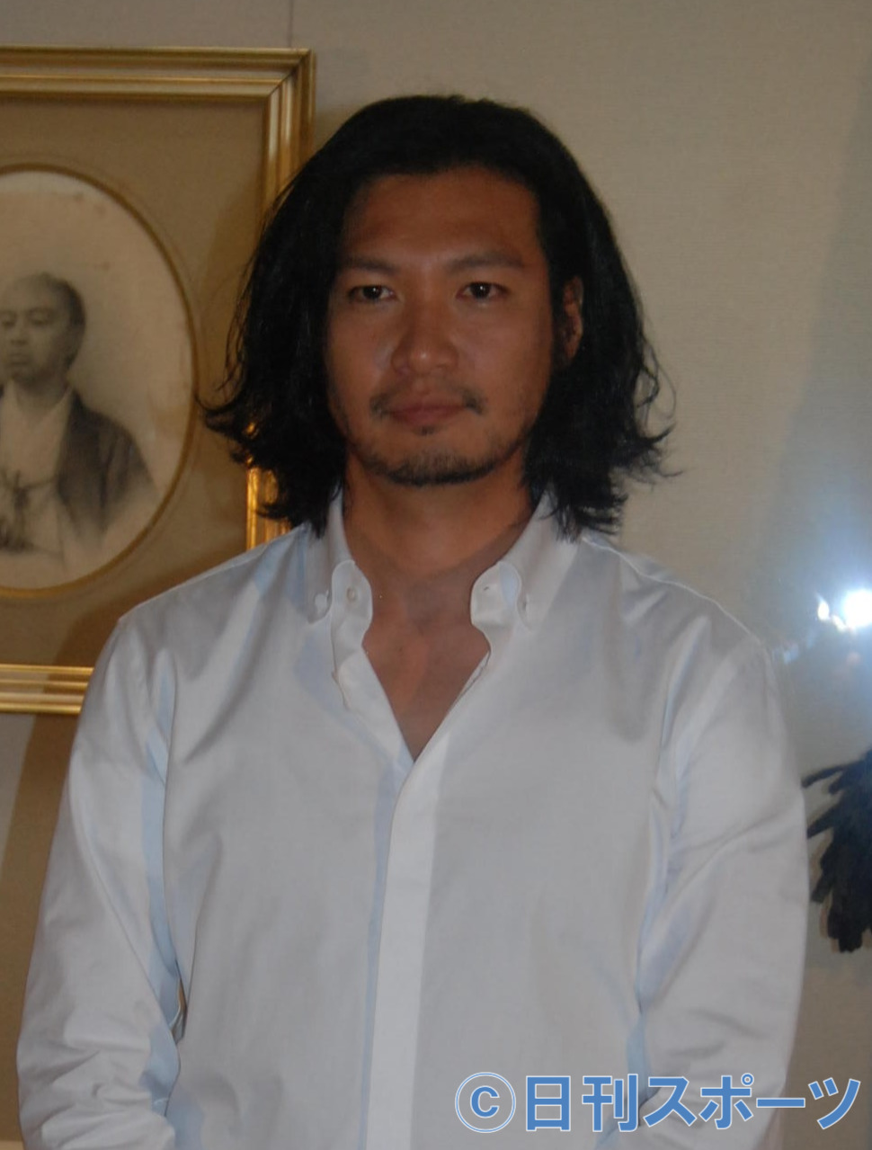 展示されている島津久光の肖像画をバックにする青木崇高（撮影・松浦隆司）