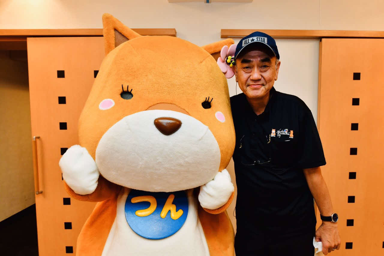 映画撮影時にお気に入りのゆるキャラ西郷つんと写真を撮る映画監督の佐々部清さん（薩摩川内市提供）