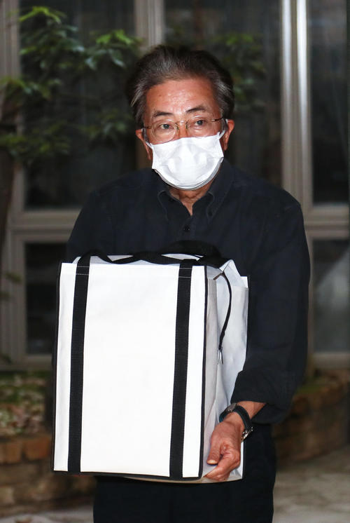 新型コロナウイルスによる肺炎で亡くなった妻・岡江久美子さんの遺骨を抱き、取材に応じる大和田獏（撮影・足立雅史）