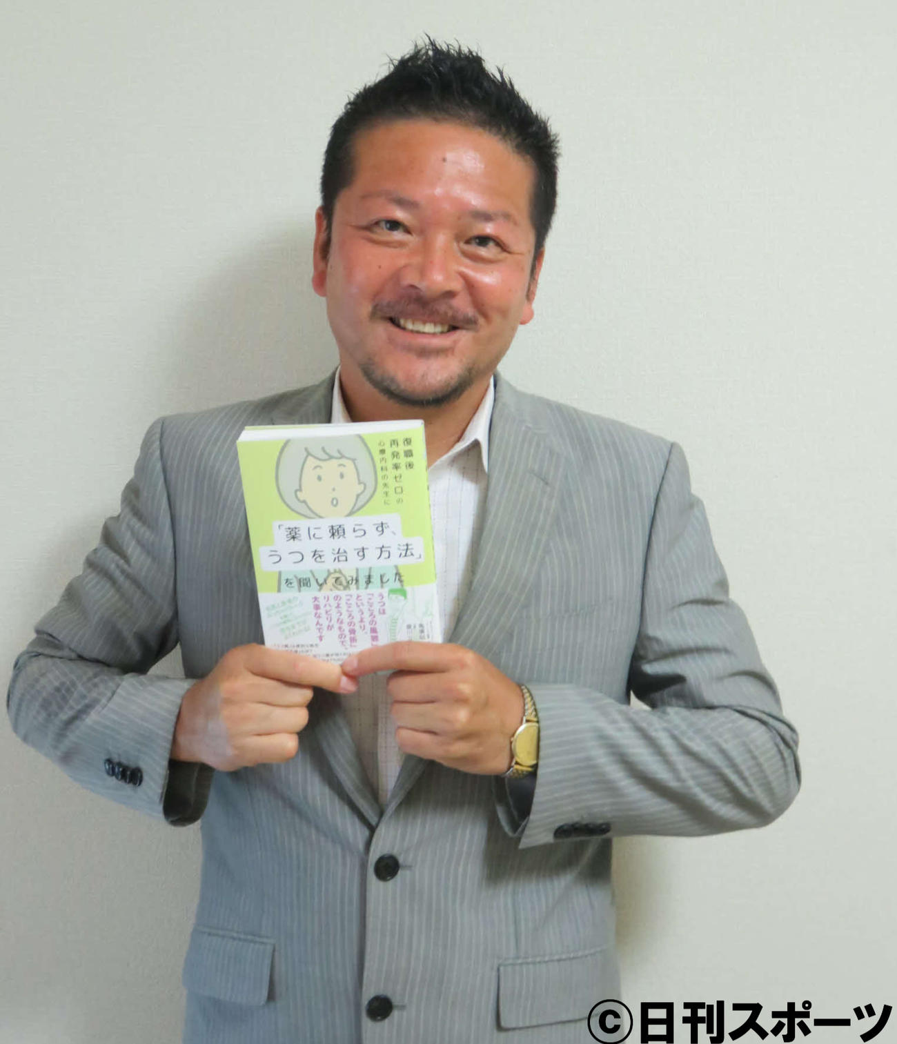 著書を手にする作家夏川立也氏