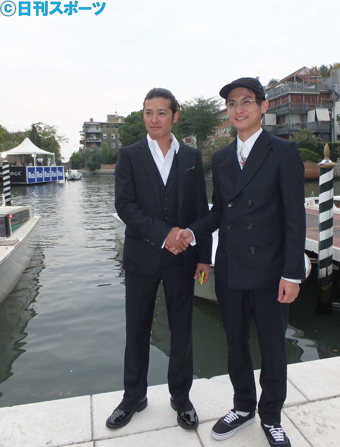 映画「千年の愉楽」で共演した高良健吾とベネチアの運河をバックに握手する高岡蒼佑（左）（12年9月撮影）