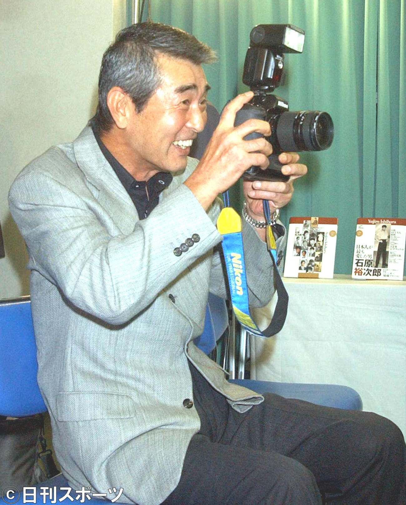 本紙記者のカメラを手に笑顔でおどける（03年6月4日）