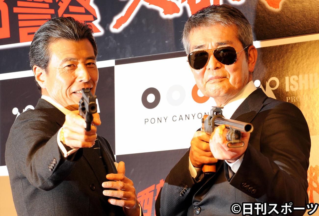 「西部警察」DVDボックス発売発表会でサングラスをかけた渡哲也さん（右）は、舘ひろしと一緒に銃を構えるポーズを取る（2012年1月12日撮影）