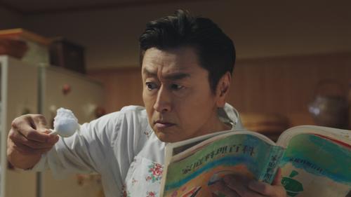 料理本片手に貴重なエプロン姿を披露する桑田佳祐